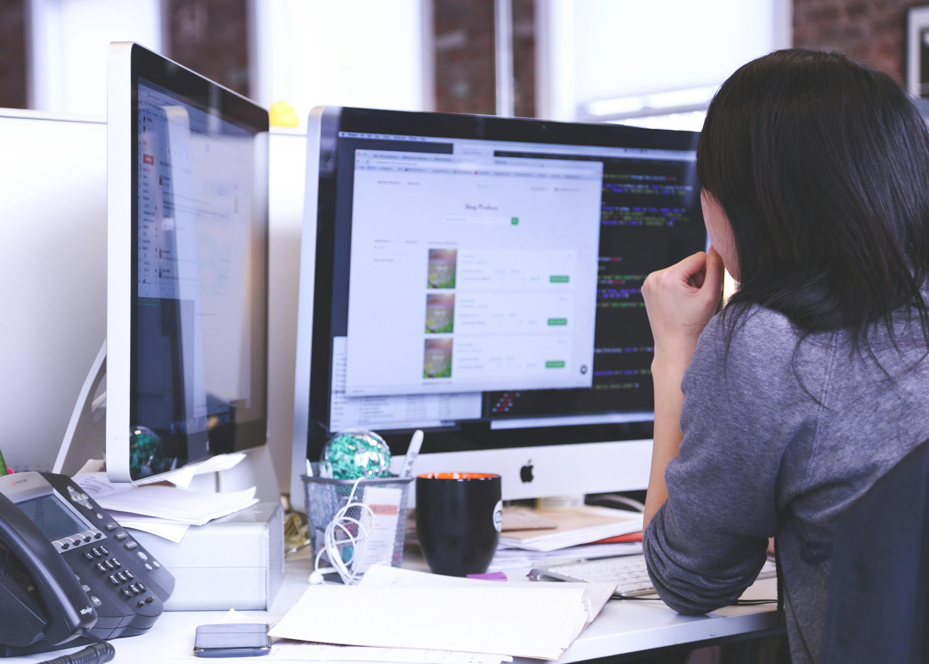 Founder working at dual monitors in a modern startup office